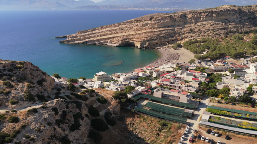 Aerial drone view of Matala bay with its sandy beach and the famous cave cliff, Matala, Greece