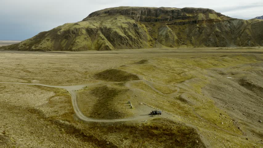 Fjallsarlon Glacier Lagoon, Oraefi, Hornafjordur, South Iceland, Iceland, shows Fjallsjokull between Breidamerkurfjall and AErfjall above a gravel access road, drone orbit