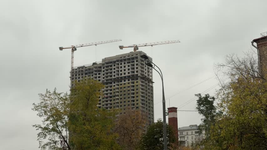 Construction site with crane and building frame, industrial development, urban growth, building progress.