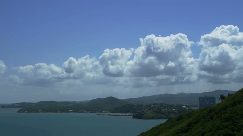 Coastal Bay Landscape With Dramatic Cloudy Sky Over Green Hills And Calm Blue Water Scenic Vista