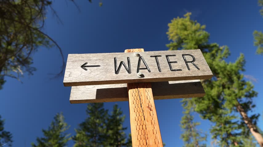 a trail sign pointing to water