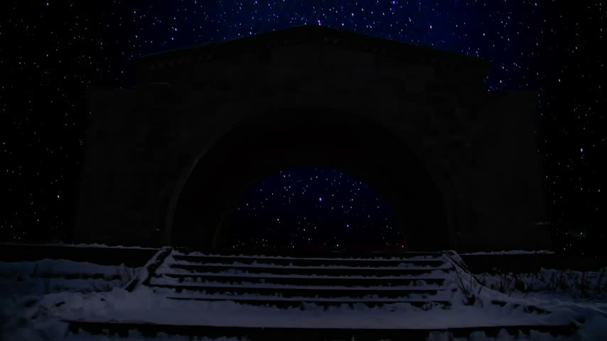Milky Way Galaxy view above Arch monument structure at night under a starry sky