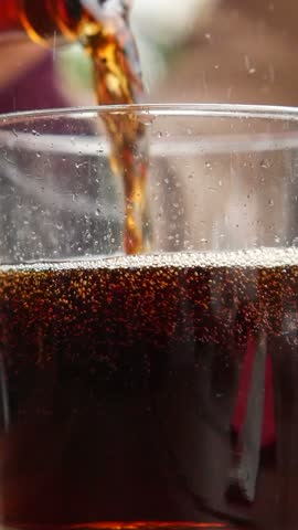 Pouring a drink into a clear glass