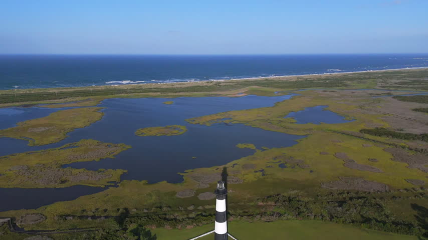 Bodie Island Lighthouse In South Nags Head, North Carolina, Within The Cape Hatteras National Seashore. Aerial Pullback Shot