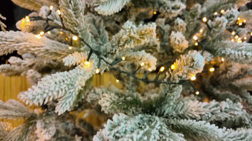 Christmas tree decorated with prominent white ornaments and elegant golden decorations, creating a bright, refined festive display for the holiday season.