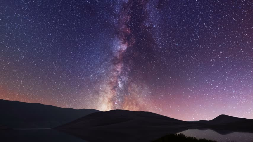 A night landscape, small lake  and mountains against a starry sky  the Milky Way.