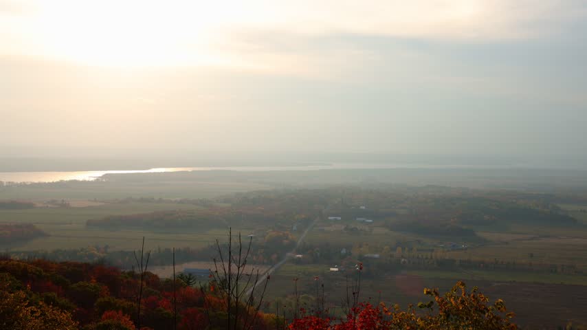 Hazy autumn sunset over rural valley landscape. Champlain Lookout in Gatineau Park, Canada.