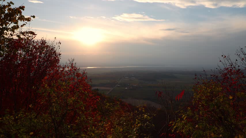 Sunset over hazy valley with autumn foliage trees. Autumnal landscape at Champlain Lookout in Gatineau Park, Canada
