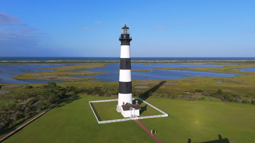 Bodie Island Lighthouse Surrounded By Flat Coastal Terrain And Marshland In The Outer Banks Of North Carolina, United States. Aerial Shot