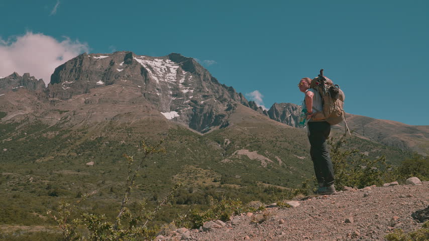 Female Hiker Standing on Ridge Looking at Mountain Peak in Torres del Paine National Park, Patagonia, Chile
