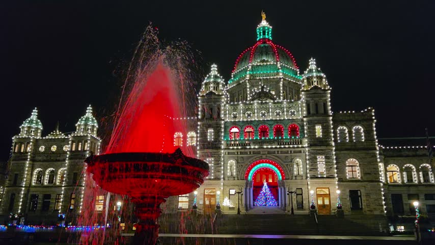 Historic British Columbia provincial parliament building and fountain at night illuminated with Christmas lights, Victoria, BC, Canada