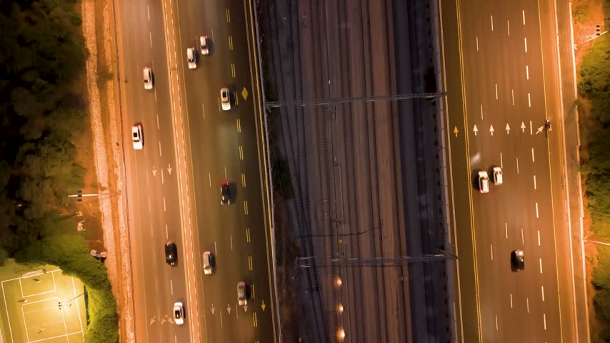 Aerial view of Ayalon North highway at night with moving cars and railway tracks in Tel Aviv-Yafo, Tel Aviv District, Israel.