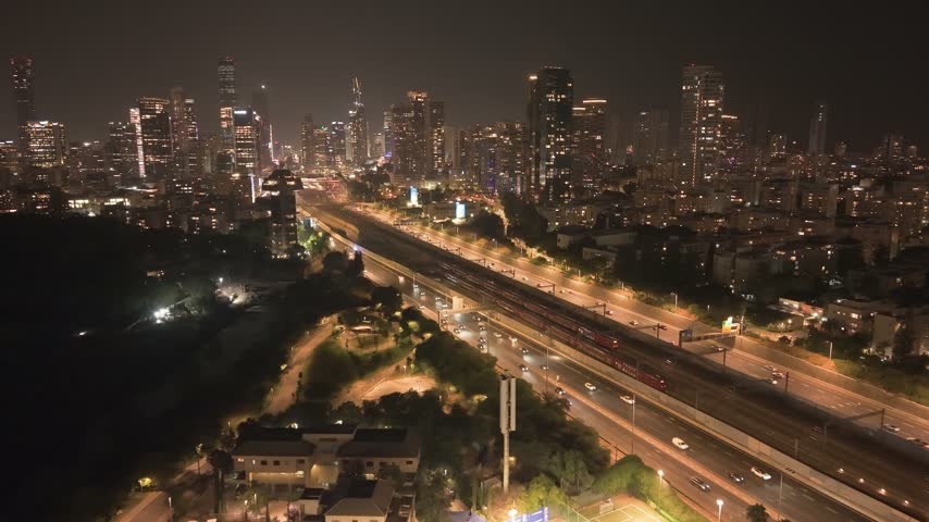 Aerial view of Ayalon North highway with traffic and the illuminated Tel Aviv skyline at night in Tel Aviv-Yafo, Tel Aviv District, Israel.