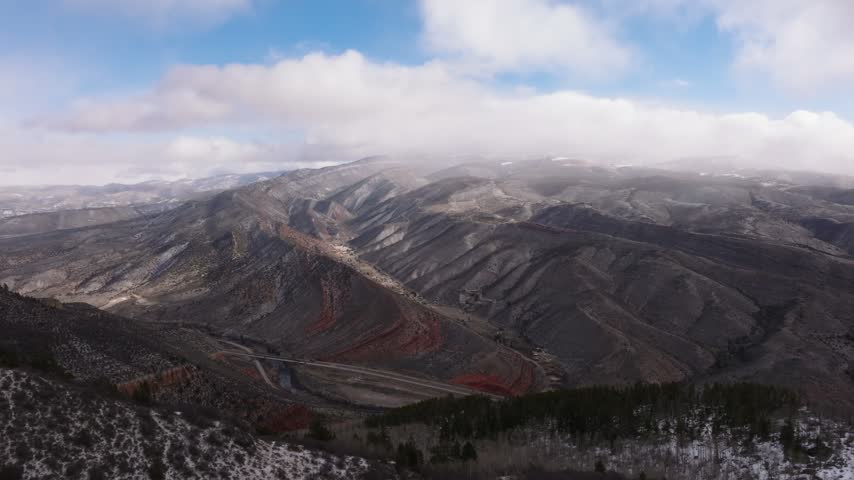 Aerial view of rugged mountains with red rock formations along Interstate 70 in the valley in Wolcott, Colorado, United States.
