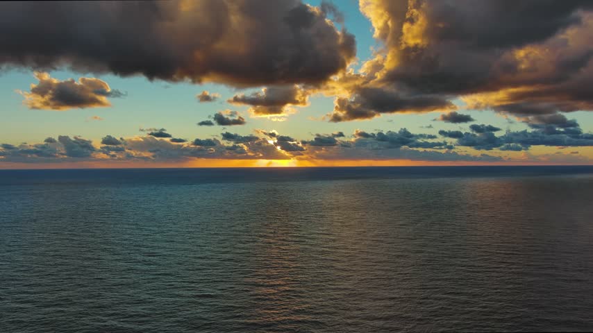 Aerial view of the sun setting over the calm waters of the Adriatic Sea in Montenegro.