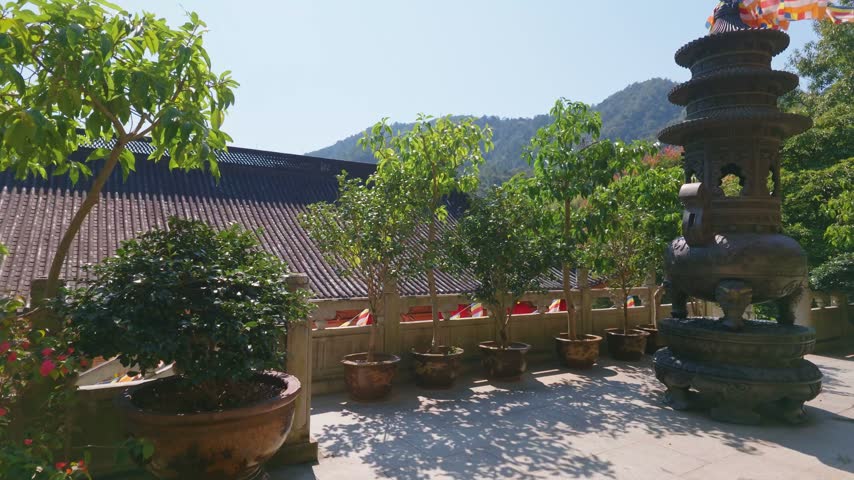 wide angle view of traditional architecture rooftop and buddhist flag decorations of Faxi Temple in the sunny morning, Hangzhou China