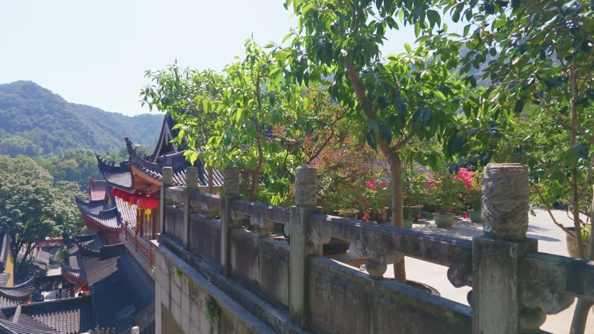 wide angle view of traditional architecture rooftop and buddhist flag decorations of Faxi Temple in the sunny morning, Hangzhou China