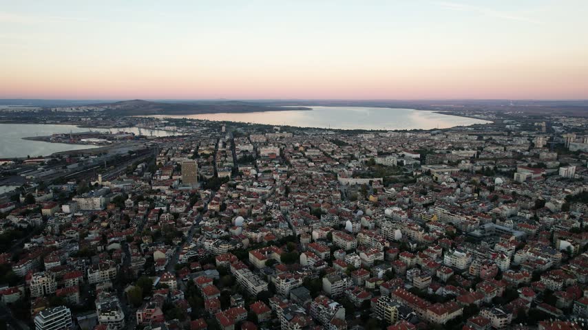 Aerial view of the city of Burgas with its dense urban rooftops and the Black Sea coastline at sunset in Burgas, Burgas, Bulgaria.