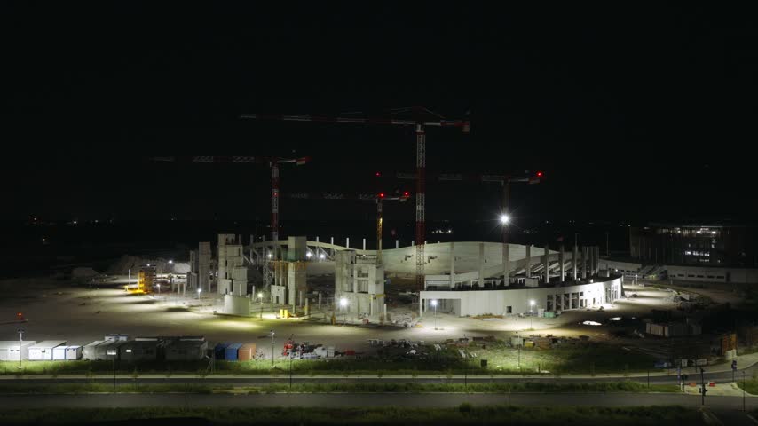 Stadium construction site at night in Venice, Italy, showing the developing stadium structure and illuminated construction area