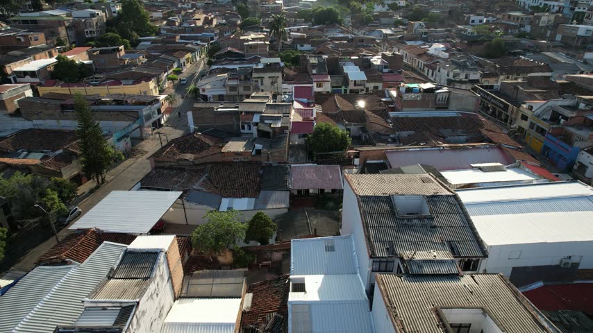 Horizontal wide-angle video of Cali, Colombia, looking toward the surrounding mountains in the late afternoon. The urban landscape stretches toward the green mountain range as the day comes to an end,
