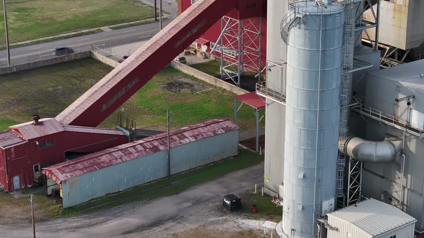 Aerial view of an industrial facility with a tall silo, red structures, and a conveyor belt in Hamilton, Ohio, United States.