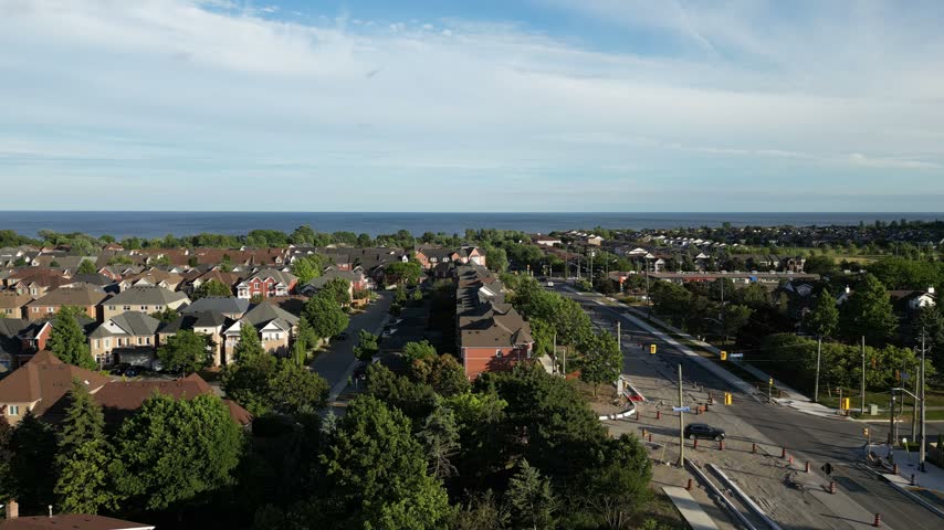 Aerial view of a railway line beside residential streets and a broad lakeshore.