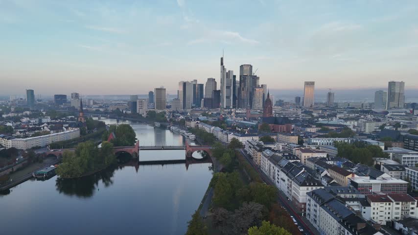 Aerial view of the Frankfurt skyline with modern skyscrapers, historic architecture, and the Main river flowing through the city in Frankfurt am Main, Hessen, Germany.