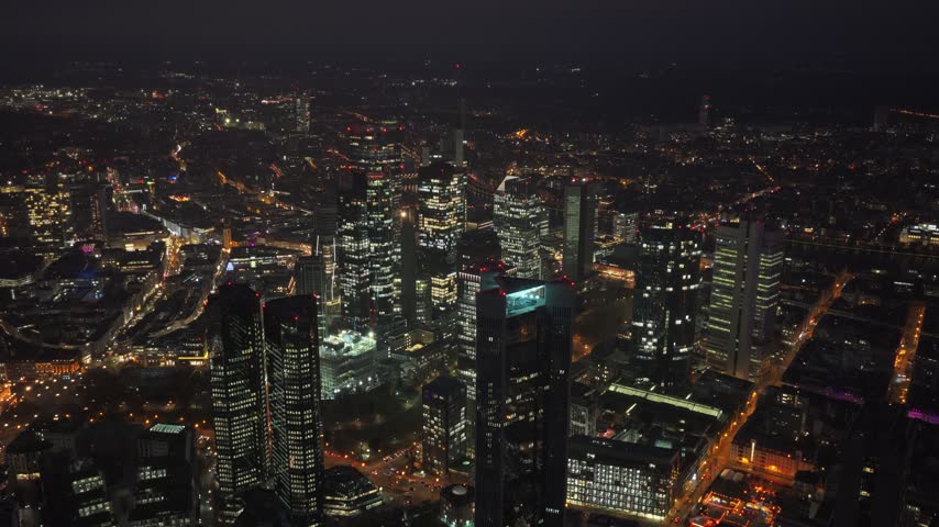 Aerial high angle hover view of Frankfurt, Germany at night: illuminated financial district skyline with smart grid overlay, grid load panel, load zones. Concept of power grid, energy management