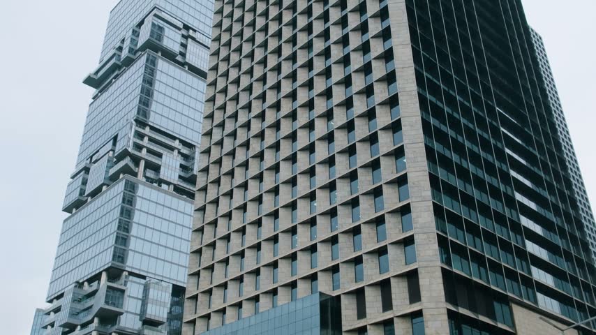 Modern high-rise buildings in Shenzhen city, China, with geometric window grids and glass facades against the sky. Skyscraper architecture, business district, corporate property, urban development