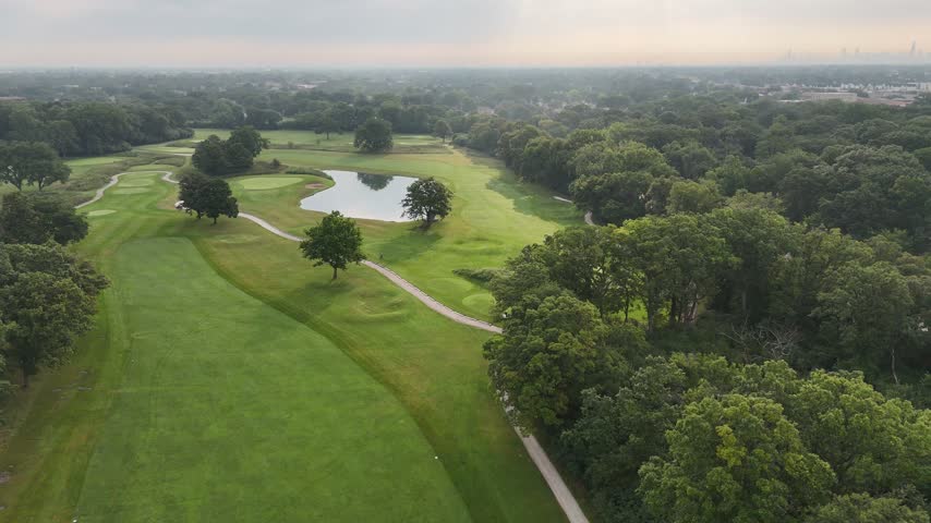 Aerial view of a tree lined golf course with sand bunkers. Filmed in River Grove, Illinois.