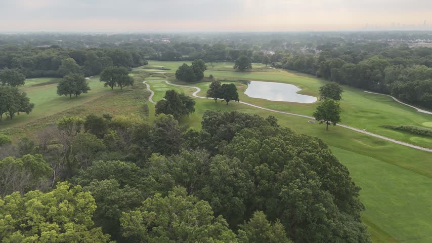 Aerial view of a wooded golf course with white sand bunkers. Filmed in River Grove, Illinois.