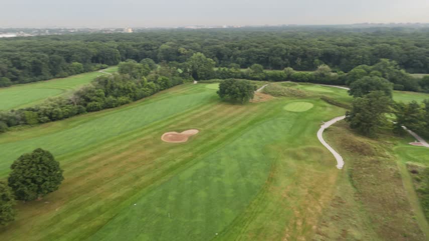 Aerial panorama of a golf course with greens and tree lines. Filmed in River Grove, Illinois.