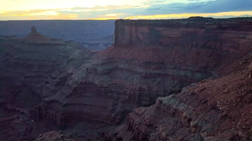 Fading evening light casts deep shadows across massive red sandstone cliffs and desert gorges at Dead Horse Point State Park Utah