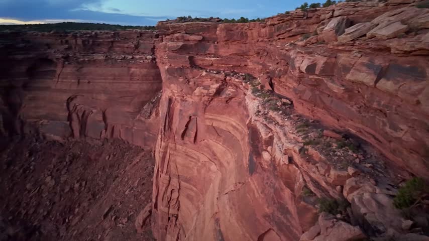 Fading evening light casts deep shadows across massive red sandstone cliffs and desert gorges at Dead Horse Point State Park Utah