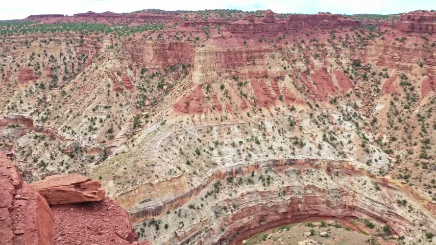 Deep carved canyon chasm drops dramatically below Goosenecks Overlook in Capitol Reef National Park Utah