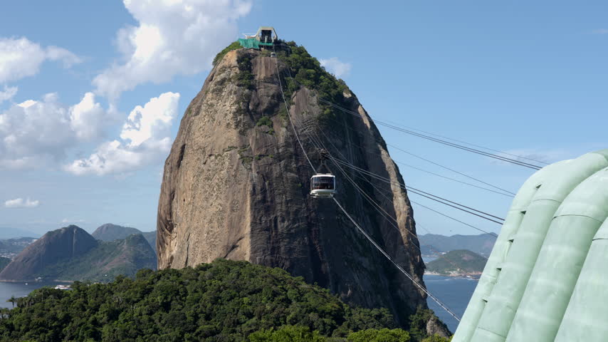 Cable car descending from Sugarloaf Mountain toward Morro da Urca on a sunny day in Rio de Janeiro, Brazil.