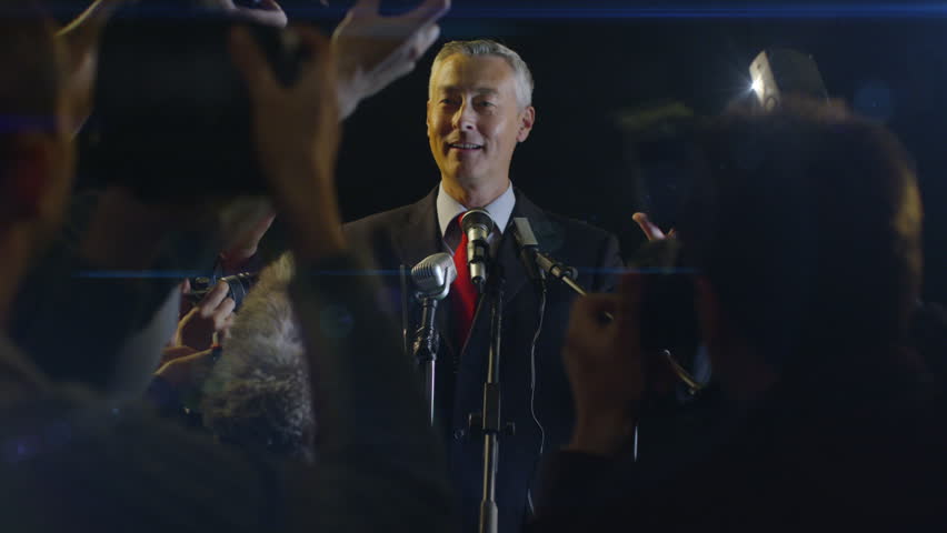 Celebrity Being Photographed By a Large Group of Paparazzi