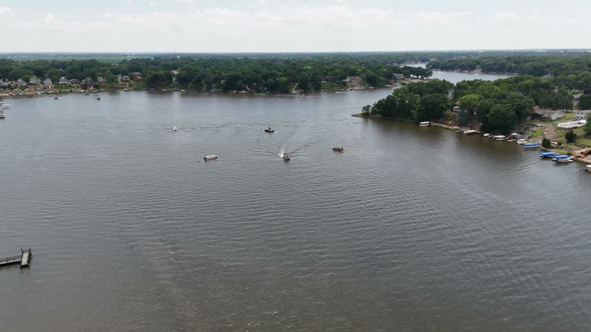 Speedboats crossing a summer lake aerial view. Filmed in Sandwich, Illinois.