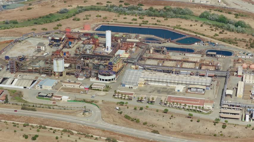 Aerial view of the Mina Cobre Las Cruces industrial facility featuring processing plants, storage tanks, and infrastructure in the arid landscape of Gerena, Andalucia, Spain.