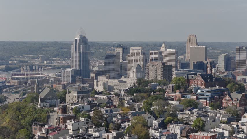 Drone aerial landscape of Cincinnati Ohio downtown center city skyline from above with many buildings, houses, apartments, churches, tall skyscrapers, and businesses near Mount Adams neighborhood hill