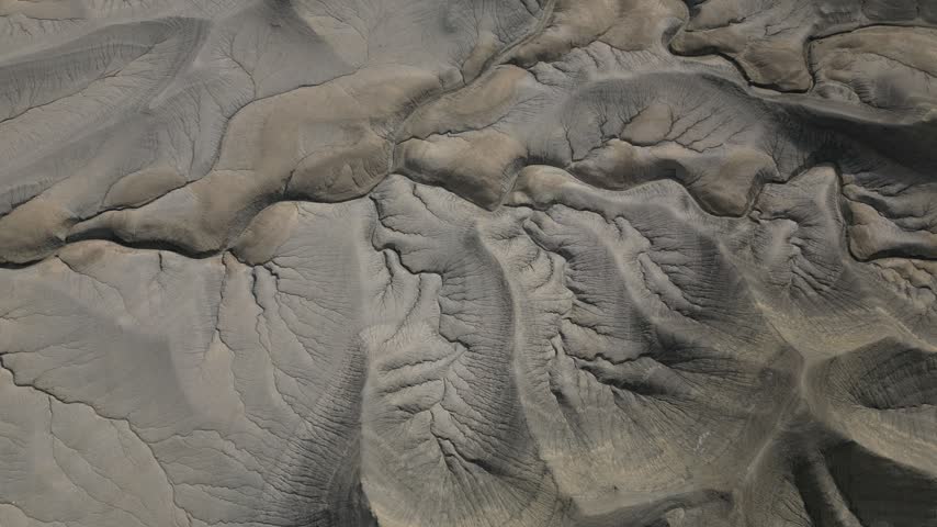 Aerial view of the rugged desert badlands with intricate erosion patterns and dry terrain in Hanksville, Utah, United States.