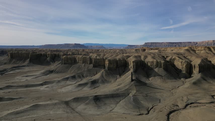 Aerial view of the rugged desert landscape with eroded cliffs and dry terrain near Hanksville, Utah, United States.