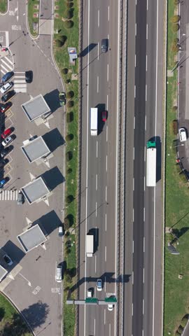 Aerial view of highway with vehicles and adjacent gas station with parking area in Milan, Lombardy, Italy.