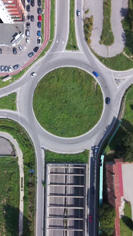 Aerial view of a roundabout with surrounding roads and green space in Milan, Lombardy, Italy.