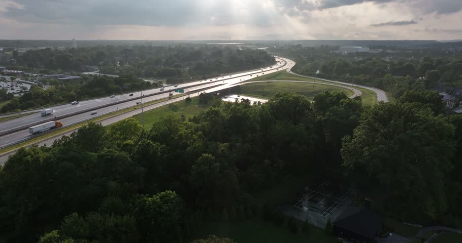 Aerial view of a highway interchange with traffic flowing through lush green surroundings under a cloudy sky in Crestview Hills, Kentucky, United States.