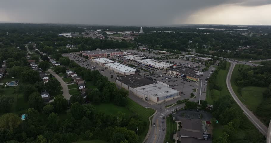 Aerial view of a shopping center with parking lots and surrounding green spaces under a cloudy sky in Crestview Hills, Kentucky, United States.