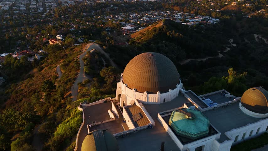 Aerial view of Griffith Observatory with its iconic domes and surrounding hillside landscape in Los Angeles, California, United States.