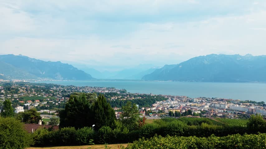 Aerial view of the town of Vevey nestled along the shores of Lake Geneva with the Alps in the background, Vevey, Vaud, Switzerland.