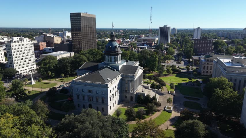 Aerial view of the South Carolina State House with the Columbia skyline behind it