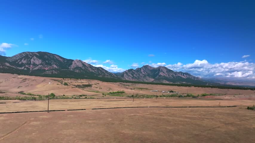 Aerial drone view vista of South Boulder of the The Flatirons Colorado summer fall autumn morning sunny blue sky Front Range Rocky Mountains Foothills City of Boulder nature landscape forward upward